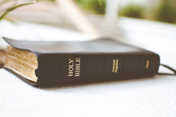 Closeup shot of the holy bible on a white surface with a blurred background