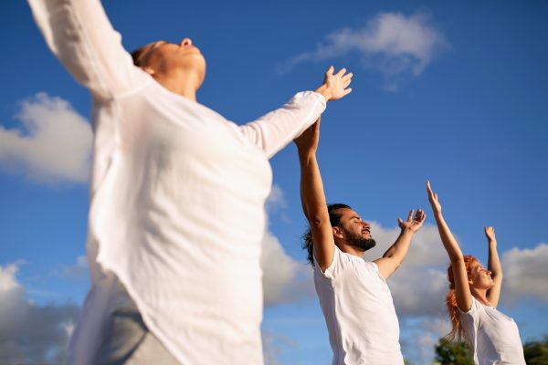group of people making yoga or meditating outdoors